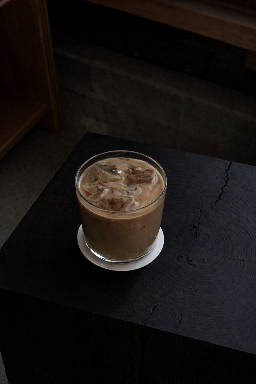 Iced hojicha latte on a dark wood table